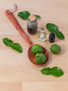 two green fruits on spoon near vials thumbnail
