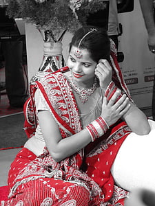 woman in red floral saree dress sitting on the sofa smiling thumbnail