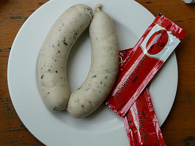 two sausages on plate with two packets of ketchups thumbnail