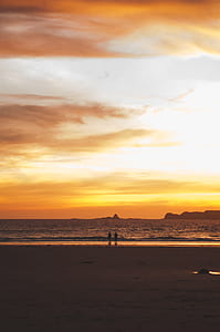 two silhouette on seashore during orange sky thumbnail