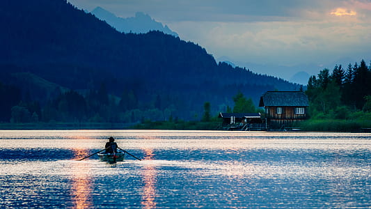 person sailing boat near brown cabin thumbnail
