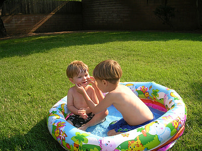two boy playing in inflatable pool thumbnail