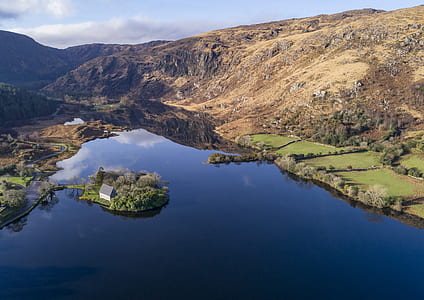 lake beside mountains and fields thumbnail