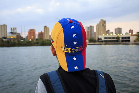 Person Wearing Black and Gray Shirt With Yellow, Blue, and Red Star Print Cap thumbnail