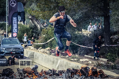man jumped over charcoal with fires thumbnail