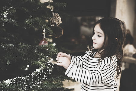 girl standing in front of Christmas tree thumbnail