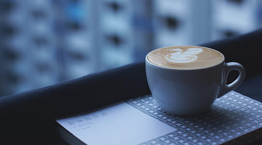 white ceramic coffee mug with designed coffee thumbnail