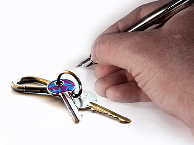 person's holding stainless steel ballpoint pen beside keys thumbnail