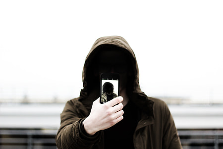 person holding phone wearing brown hoodie thumbnail