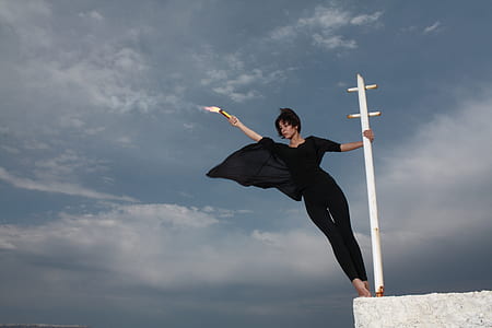 woman in black 3/4-sleeved jumpsuit on white metal post thumbnail