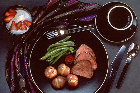 medium rare steak, potato, and green beans on black plate thumbnail