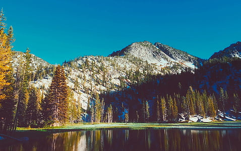 photo of mountain range near lake thumbnail