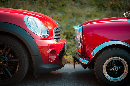 closeup photography of red Mini Cooper and classic red Mini Cooper during daytime thumbnail