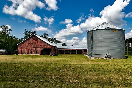 brown wooden barn house beside gray tank during daytime thumbnail