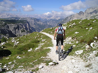 man riding mountain bike on peak near gray mountains at daytime thumbnail