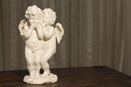 selective focus photography of ceramic cherubs figurine thumbnail