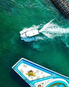 white motor boat sailing in body of water thumbnail
