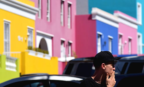 man smoking near vehicle during daytime thumbnail