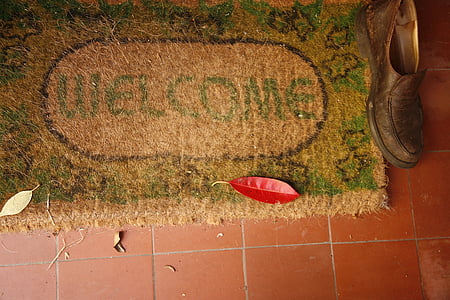 brown and green welcome mat on brown floor tiles thumbnail