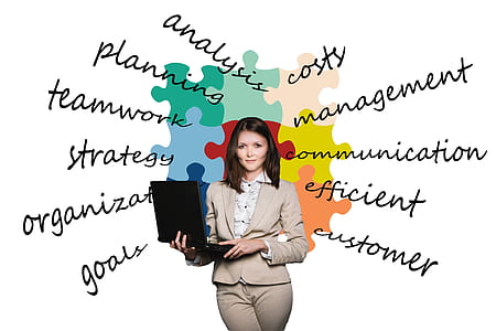 woman in beige blazer and pants holding black laptop computer thumbnail