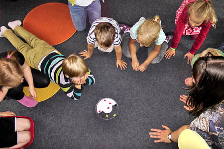 children looking gathering around toy thumbnail