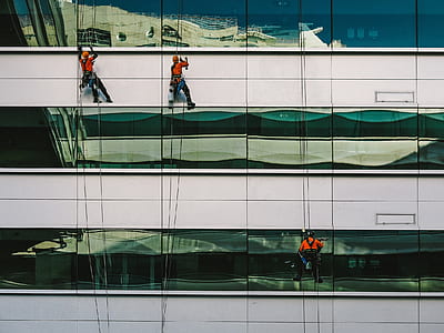 three person climbing on building at daytime thumbnail