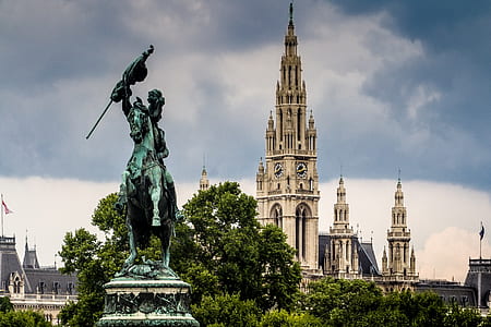 man riding horse statue near white concrete building during daytime thumbnail