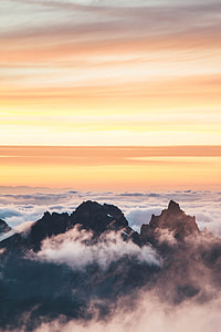 mountain peaks under white and yellow sky thumbnail