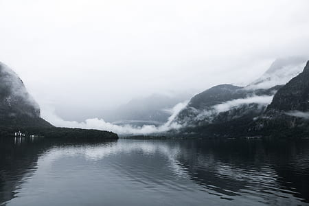 grayscale photography of body of water and mountains thumbnail