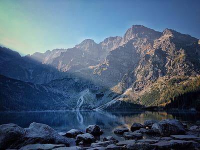 landscape photography of brown mountains and body of water thumbnail