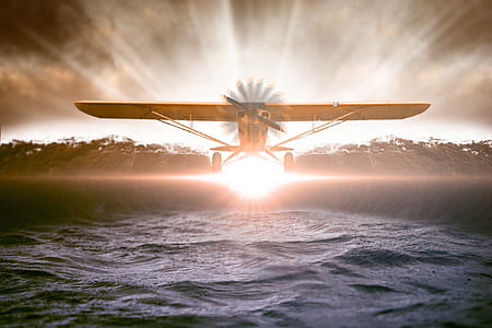 brown crop duster above body of water with sun light painting thumbnail