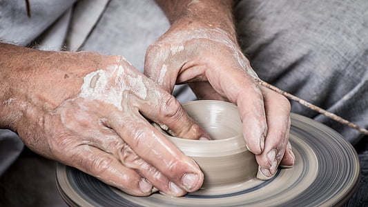 person molding gray clay pot thumbnail