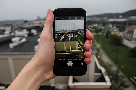 person holding iPhone showing building rooftop thumbnail