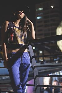 woman standing beside handrail during nighttime thumbnail