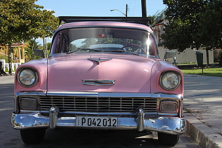 pink car parked beside gray concrete pathway thumbnail