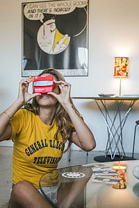 sitting woman on floor in front of glass table red projector toy inside white room thumbnail