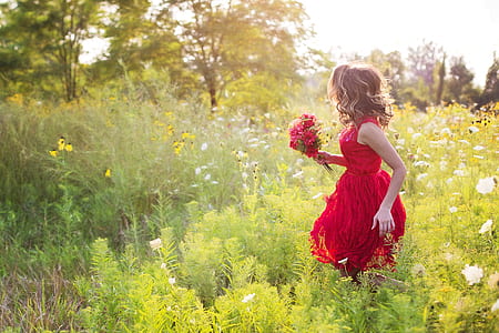 woman wearing dress while carrying bouquet of flower on a flower field thumbnail