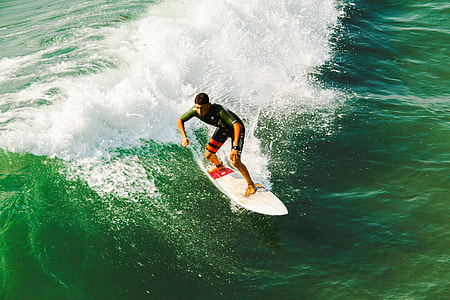 man rides on white surfboard during daytime thumbnail