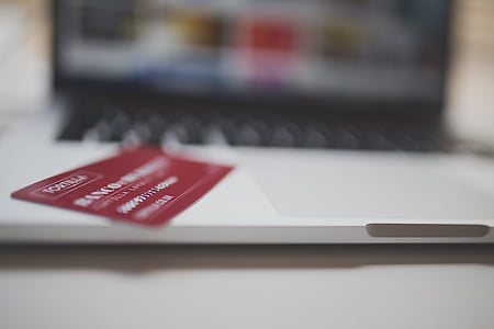 red card on top of silver and black laptop computer thumbnail
