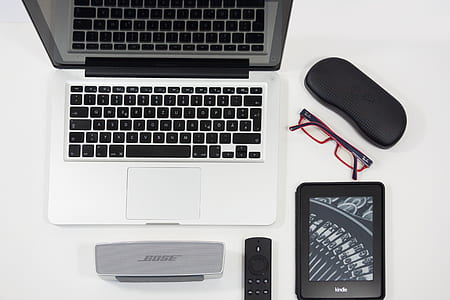 gray laptop computer beside speaker and e-book reader thumbnail