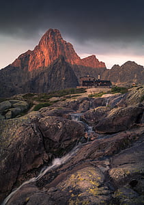 brown mountain near black house thumbnail
