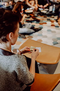 Women folding sheet of paper while making origami thumbnail