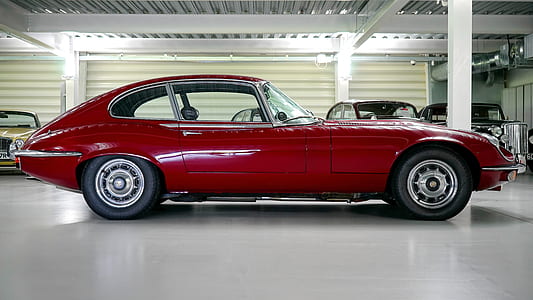 classic red coupe parked near cars thumbnail