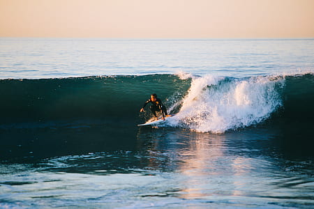 man surfing on waves during daytime thumbnail