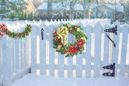 green and red Christmas wreath on white wooden fence thumbnail