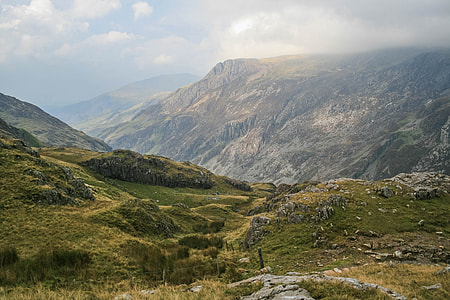 foggy green mountains under cloudy sky thumbnail