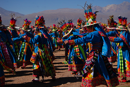 group of people in traditional dress dancing in open field thumbnail