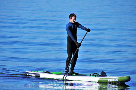 man on paddleboard floating on body of water thumbnail