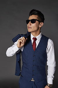 man holding blue suit jacket facing right side thumbnail