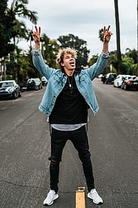 man wearing black top and pants standing on concrete road thumbnail